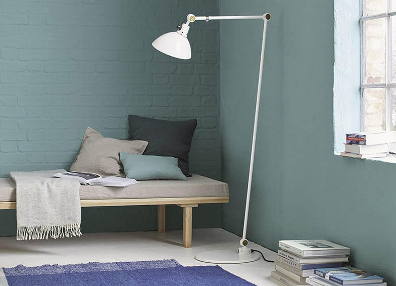 Minimalistisch wohnen: Schlafzimmer mit blauer Wandfarbe, Couch und Büchern