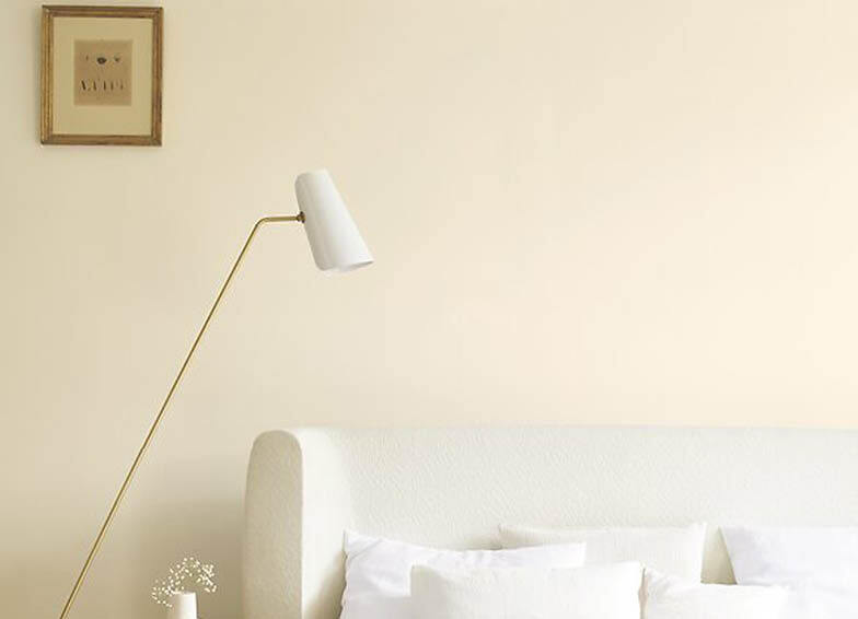 Wandfarbe warmes Lichtweiß im Raum mit Bett und Lampe