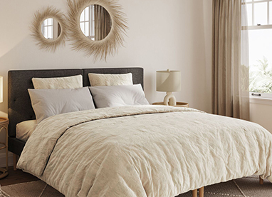 Modernes Schlafzimmer mit Bett, heller Wand und heller Bettwäsche