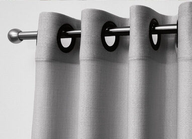 Grauer Stoffvorhang an metallener Gardinenstange