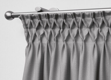 Grauer Stoffvorhang an metallener Gardinenstange