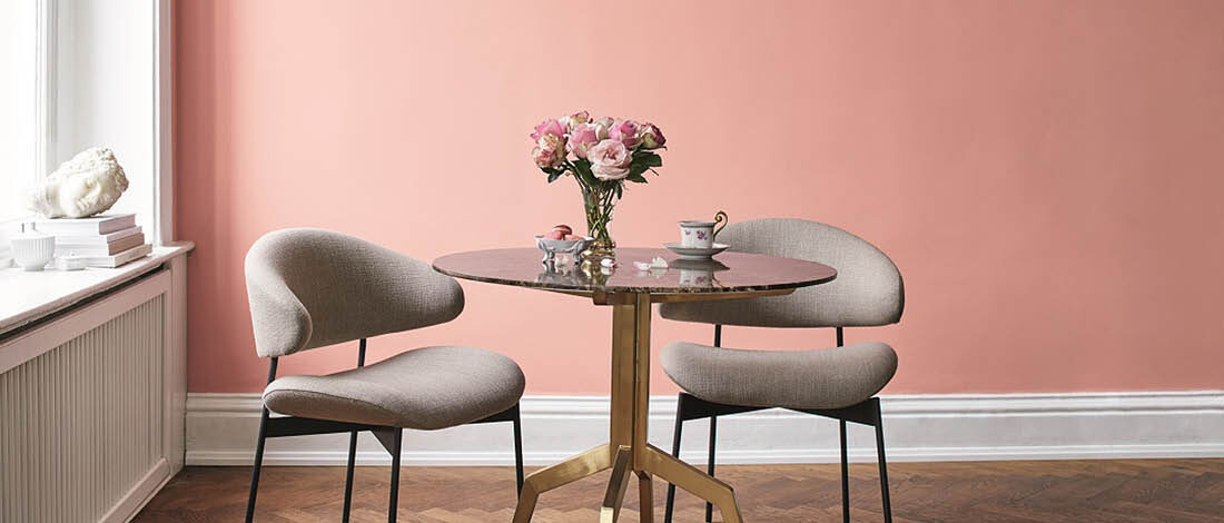 Rosa-farbenes Zimmer mit zwei grauen gepolsterten Stühlen und einem Beistelltisch
